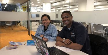 A student and a Peer Financial Counselor smile during their counseling session